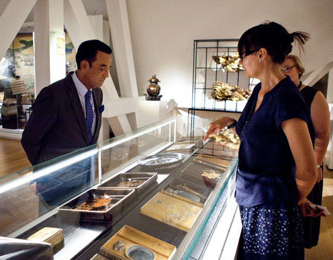 ambasador Peru ogląda japońskie pudełka do kaligrafii na wystawie