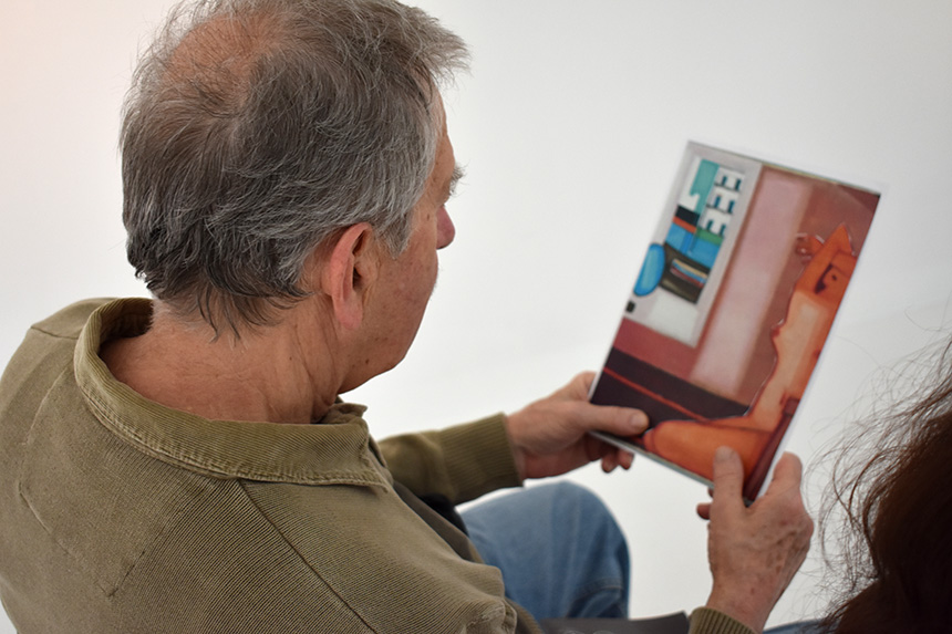 siedzący mężczyzna ogląda obraz Akt autorstwa Jerzego Nowosielskiego