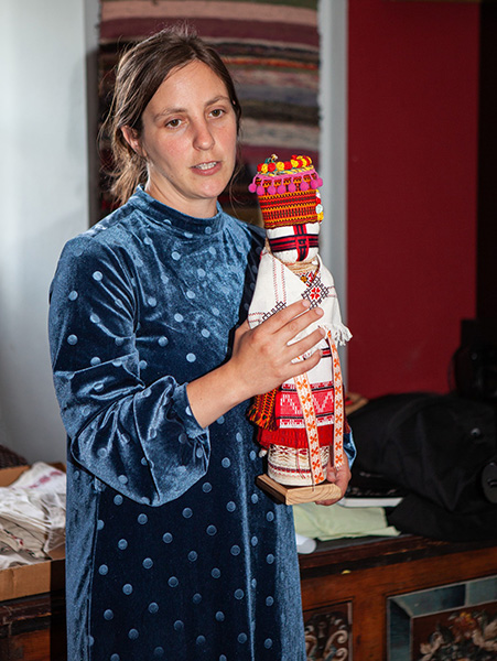 prowadząca prezentuje haftowaną lalkę