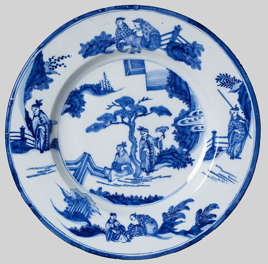 niebiesko zdobiony talerz z drzewem i postaciami pod nim