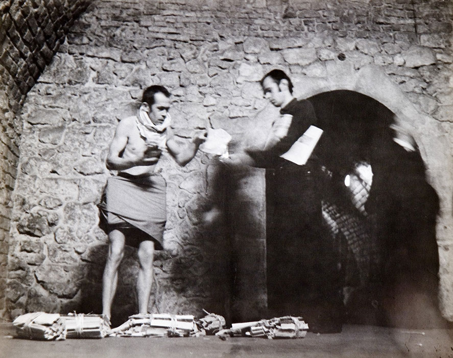 czarno-biale zdjęcie przedstawiające dwójkę artystów na tle kamiennej ściany