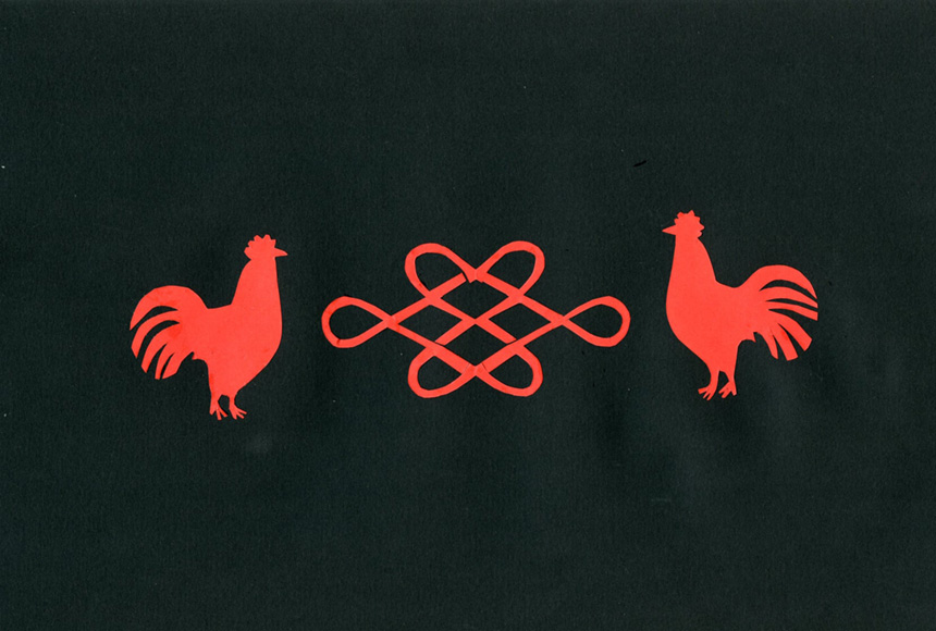Na czarnym tle czerwone figury wycięte z czerwonego papieru. Koguty zwrócone do siebie dziobami oraz umieszczony między nimi chiński znak nieskończoności.