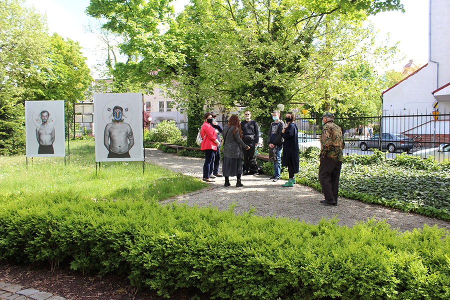 Uczestnicy spotkania stoją w ogrodzie przed muzeum