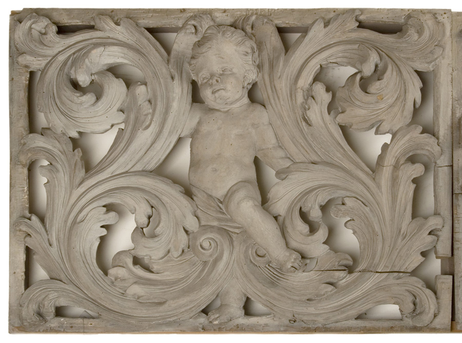 barokowo rzeźbione akantowe zawijasy, w środku sympatyczny bobas putto