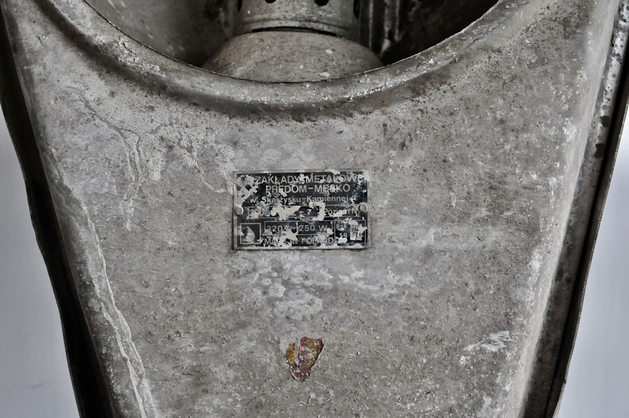 Lampa Piotra Skiby (fragment z napisem o zakładach metalowych)