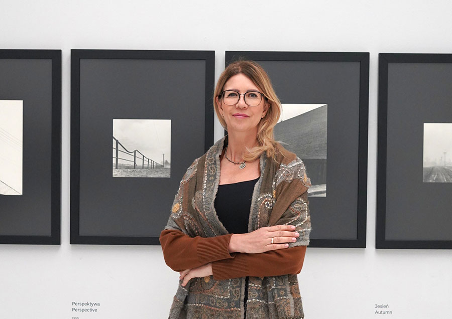 Kuratorka Agnieszka Błaszczyszyn na tle fotografii Zdzisława Beksińskiego